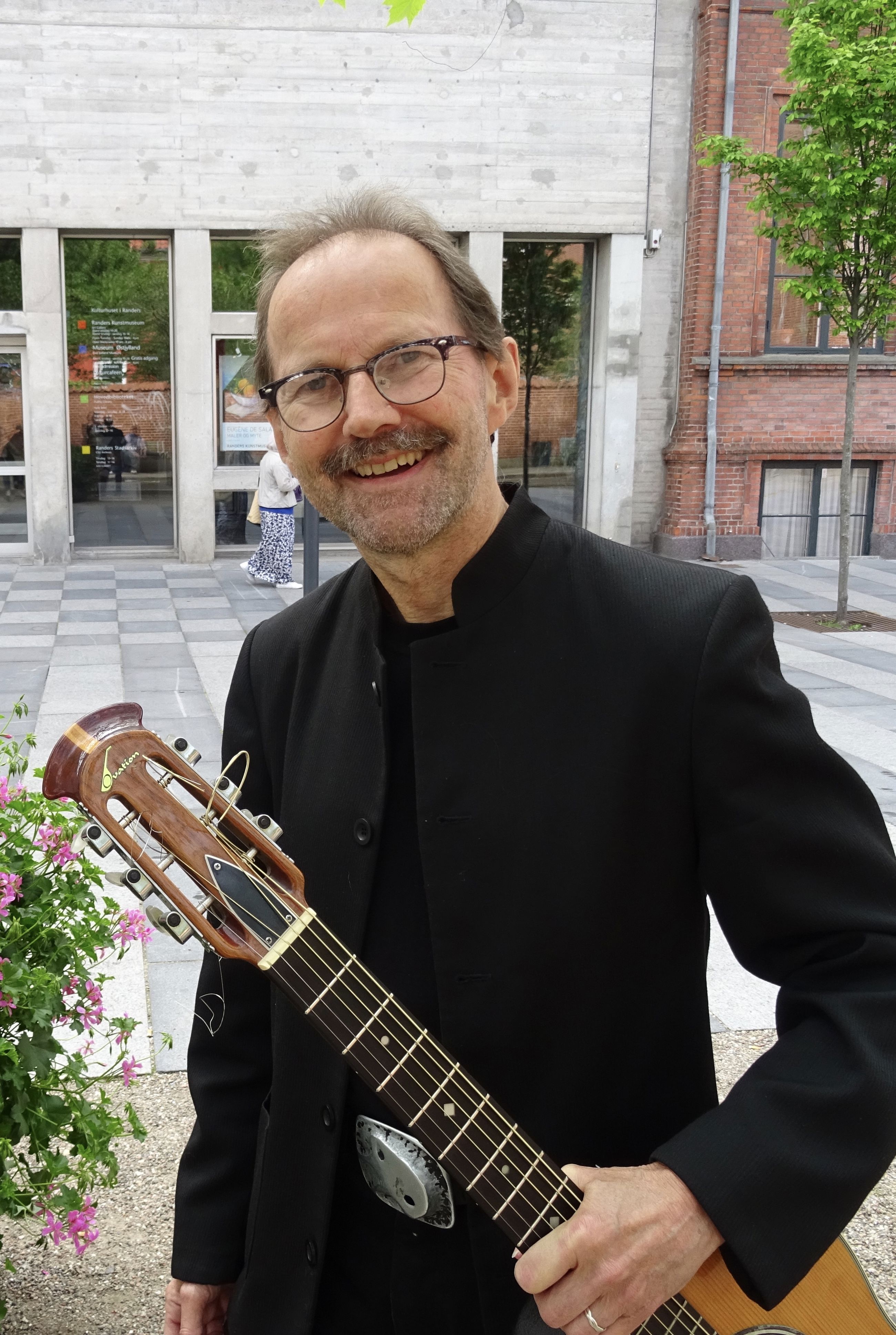 Biblioteksmusikanten Peter Elmelund med sin guitar